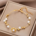 Gold multi-layer bracelet featuring floral charms and white pearls on jewelry box - Gold Pearl Large Flower Multi-layer Bracelet (5082)