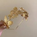 Elegante cerchietto in metallo dorato con vari ciondoli a farfalla tenuto in mano - 11# Cerchietto-Farfalla Dorata
