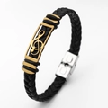 Close-up of black braided leather bracelet with golden music note metal accent - Music Note