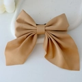 Caramel fabric bow hair clip with long ribbons on minimalist white ceramic tray - Khaki