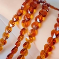 Macro shot of faceted amber crystal heart beads showing transparent texture and glossy finish - Amber