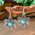 Macro shot of silver filigree flower earrings with turquoise stone on a wooden branch - Hollow Filigree Flower (HQEF-1588)