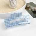 Medium blue checkered acrylic hair claw clip with glitter finish on white desk - 10.5cm / Blue