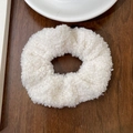 Gros plan d'un chouchou blanc en peluche teddy sur une table en bois rustique - Blanc