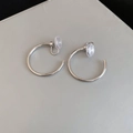 Detailed macro view of silver C-shaped clip-on earrings with clear silicone pads - 3cm / Silver / Clip-On Earrings