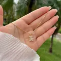 Detailed view of an 18K gold plated bear pendant necklace with sparkling white zircons - Pink