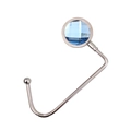 Macro shot of silver metal bag hook with a blue faceted gemstone on white background - Blue