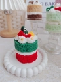 Close-up of a double-layer Christmas strawberry cake scented candle with festive decor - Christmas Cake (Oud Bergamot & Strawberry)