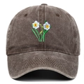 Close-up of vintage washed cotton baseball cap with white flower embroidery details - Coffee