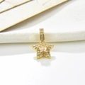 Dettaglio ravvicinato di un ciondolo a stella dorato con zirconi micro-pave e gemma centrale - Bianco