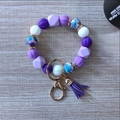Detail of purple silicone beads with floral patterns and a suede tassel keychain charm - Dark Violet