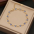 Close-up of golden stainless steel bracelet with blue heart-shaped enamel evil eyes - Royal Blue