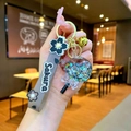 Detail of Sakura themed keychain featuring clear sequin bubble and grey wrist strap - Black Luminous Bubble Bead Lollipop