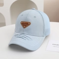 Dettaglio del cappellino trucker in mesh azzurro con visiera usurata e placca Lucky Baby - Etichetta Triangolare (Blu Chiaro)