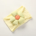 Macro detail of soft nylon baby headband with knitted flower in yellow and green - Beige