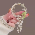 Golden hair clip with white flower tassels and green leaves shown on back of head - F0441 Gold Purple Tassel