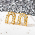 Gros plan de boucles d'oreilles en U en acier inoxydable plaqué or 18 carats - Forme en U