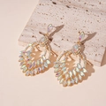 Macro detail of gold teardrop earrings with shimmering AB marquise crystals on stone texture - AB Rainbow