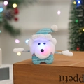Close-up of glowing plush bear Christmas wristband on rustic wood with bokeh lights - Sequin Glowing Bear