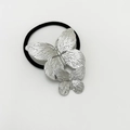 Elastic black hair tie featuring two textured silver metal butterflies on a white background - Double Butterfly / Silver