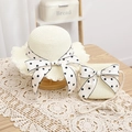Close-up of children's straw sun hat and matching bag set with polka dot bows - Milk White Set