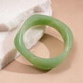 Detalle del brazalete de resina verde con textura jaspeada sobre soporte de piedra - Textura de Jade Translúcido Ancho (HB4273) / verde claro