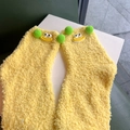 Detail of warm yellow coral fleece socks with 3D cartoon eyes and green pom poms - Yellow
