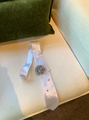 Detailed view of a white satin necktie necklace featuring a silver fabric rose and pearl accents - Flower Necktie Style / White