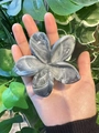 Detailed macro view of 8cm marble-textured floral hair claw clip held against green leaves - 8cm / Black