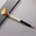 Detail eines schwarzen Kugelschreibers mit gelben Kristallen und orangefarbenem Rohstein - Citrin