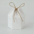 Close-up of white hexagonal paper gift box with a brown jute twine ribbon bow - White