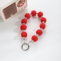 Detail of red plush ball bag charm with silver beads and O-ring spring clasp - Red