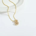 Close-up of golden bubble letter S pendant necklace with sparkling stone inlay - S