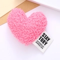 Pink plush heart-shaped accessory with white fabric brand tag for clothes and hats - Pink