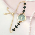 Gros plan sur la montre quartz dorée avec cadran vert et bracelet à bijoux feuilles - Or Noir