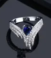 Elegant silver ring featuring a pear-cut blue gemstone with wing-shaped pave accents - Ur0581c
