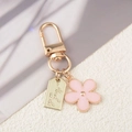Portachiavi con fiore in metallo rosa con fibbia dorata e ciondoli portafortuna - Rosa