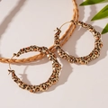 Dettaglio di grandi orecchini a cerchio stile bambù con stampa leopardata vintage - Orecchino a Cerchio Leopardato