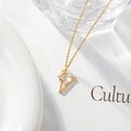 Detail of gold letter V necklace with zircon flower pendant on creative background - Letter V
