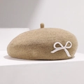 Nahaufnahme einer kamelbraunen Strickbaskenmütze mit einer zarten weißen 3D-Schleife - Verstellbar / Beige/Khaki (Weiße Schleife)