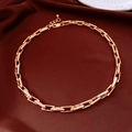 Dettaglio della collana a catena dorata con maglie rettangolari su sfondo di seta - Oro