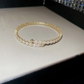 Macro detail van gouden armband met rechthoekige zirkonia stenen en glanzende sterreflectie - Rechthoekige Open Stijl / Goud
