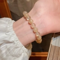 Golden rutilated quartz beaded bracelet worn on wrist with white pleated sleeve - Rutilated Quartz Titanium Quartz Style (21# with Gift Box) / 10mm