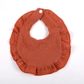 Close-up of burnt orange double layer cotton gauze baby bib with ruffled edge and snap - Brick Red