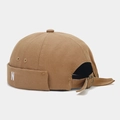 Detail of docker hat with N embroidery, vintage metal buckle and canvas texture - Caramel color
