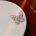 Dettaglio dell'orecchino a polsino a farfalla in argento con zirconi su vassoio bianco - Ear Cuff - Argento - Orecchio Sinistro