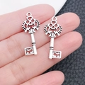 Antique silver vintage heart key pendants in hand showing size for DIY jewelry making - Hollow Key 13x28mm (3333)