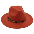 Detail of the leopard print band and golden buckle on a brick red wool fedora hat - Caramel color