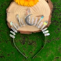 Couronne de lune en cristal bohème avec piliers irisés sur fond de mousse et bois - Style Lune Verticale en Cristal Aurore