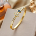 Luxe gouden klaverarmband van staal met zwarte inleg en fonkelende kristallen - Goud